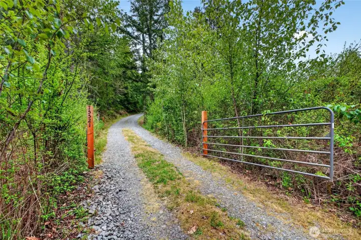 The gated entrance welcomes you up this well maintained gravel road.