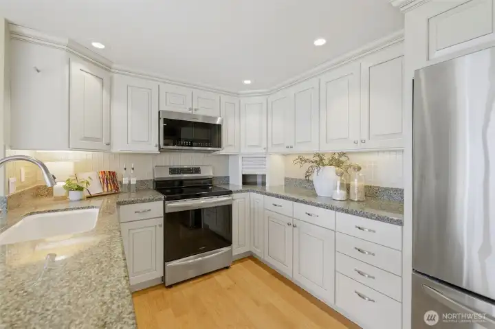 Updated kitchen featuring a newer dishwasher (2023), range (2022), microwave (2025), kitchen faucet (2020), and under-cabinet lighting Updated kitchen featuring a newer dishwasher (2023), range (2022), microwave (2025), kitchen faucet (2020), and under-cabinet lighting