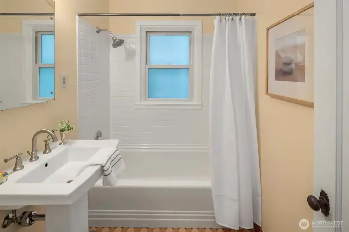 Fully tiled main bath positioned between the two upstairs bedrooms.