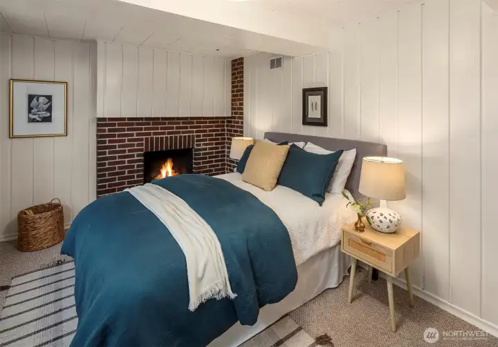 Additional lower-level bedroom or media space with wood-burning fireplace.