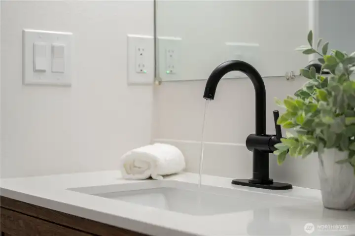 Modern black fixtures and updated electrical outlets, switches, and plumbing fixtures throughout the home.
