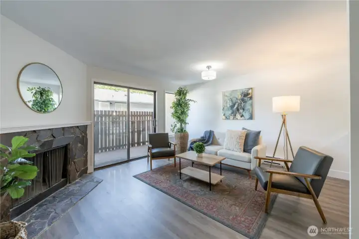 Open living room with fireplace and sliding glass door leading to the private patio.