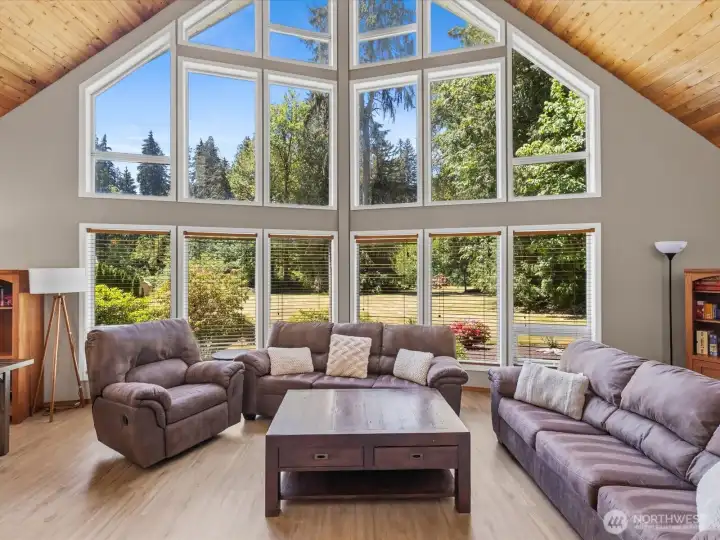 Fantastic living room with full wall of windows and beautiful tongue-in-groove pine ceiling.