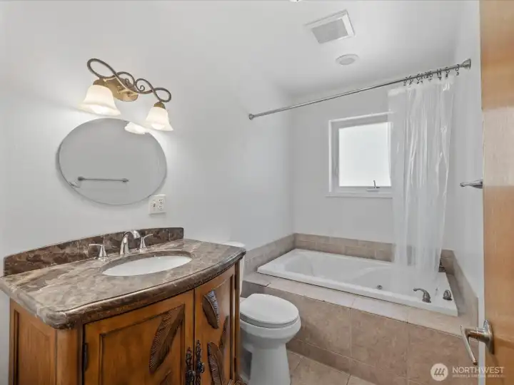 Full bath on the main level features a jetted tub.
