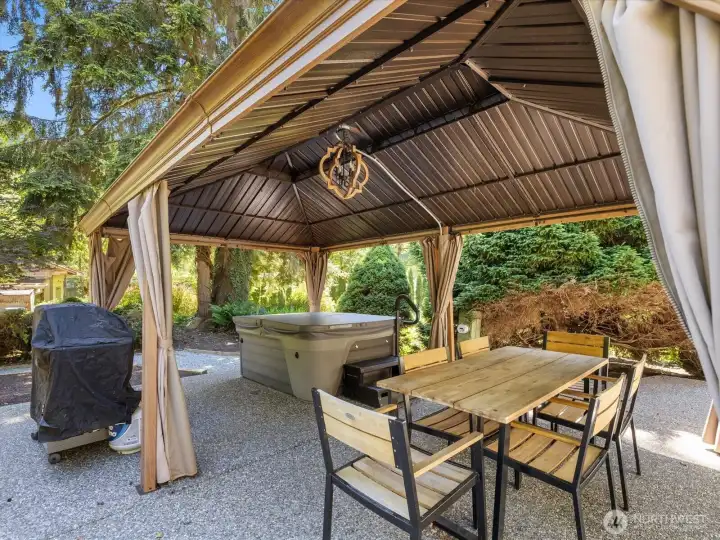 Ready for any weather, the covered patio has dining space and a hot tub.