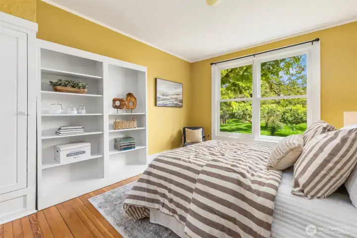 Bright main floor bedroom features large windows and built-ins.
