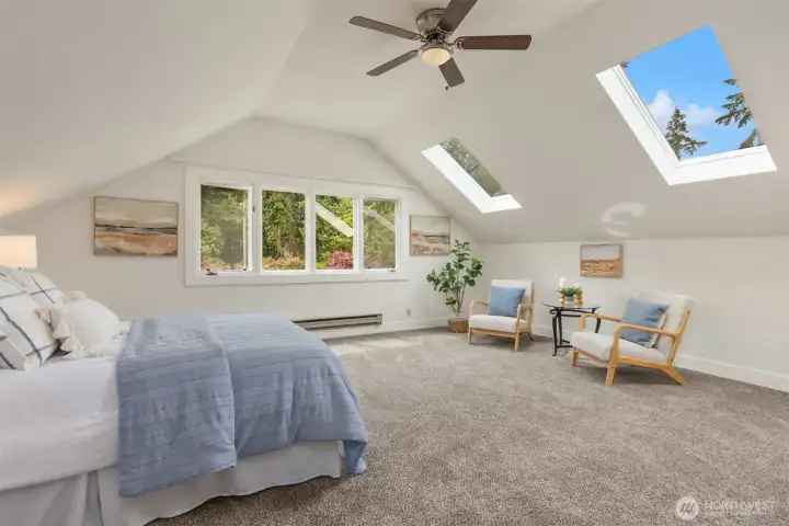 Upstairs, the spacious, vaulted primary bedroom enjoys skylights, large windows, and an ensuite bathroom.