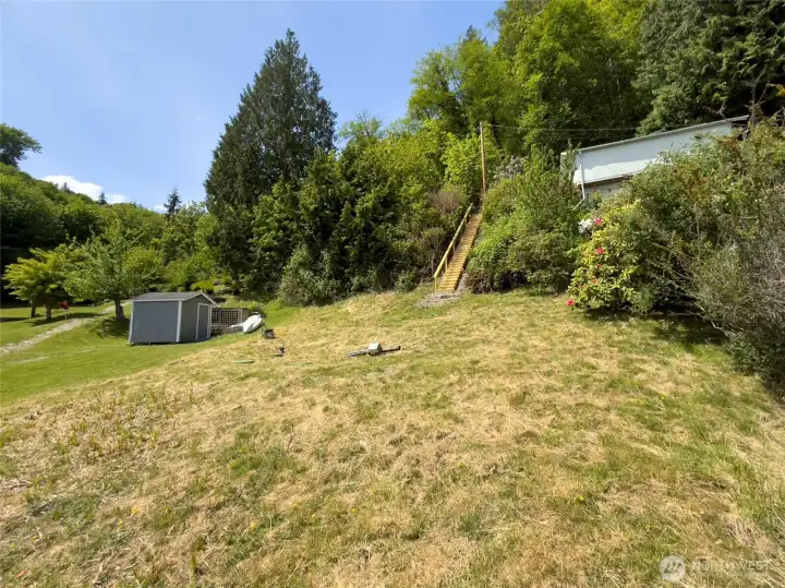 The newly installed stairway leads to a level area at the base of the property, creating space to gather, relax, play, and enjoy time outdoors. Whether you're envisioning lawn games, beach picnics, or evenings around a firepit, this waterfront setting offers plenty of room to make it your own.