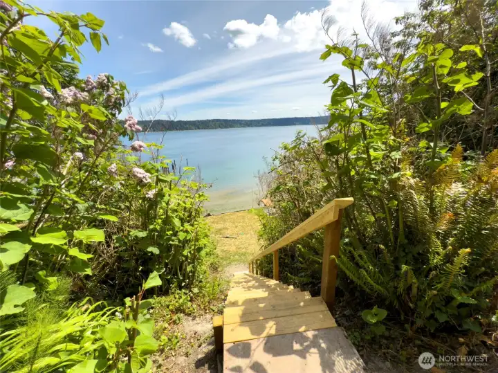 Follow the stairs toward the shoreline and imagine arriving home to this view every day. Looking across Colvos Passage toward Vashon Island, it's easy to see why waterfront living remains one of the Pacific Northwest's most sought-after lifestyles.