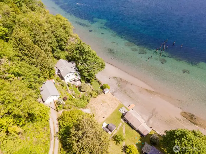 This aerial perspective highlights the property's relationship to both the shoreline and the surrounding landscape. The parcel extends across both sides of the road shown here, offering a unique configuration and an exceptional opportunity to create your own waterfront retreat.