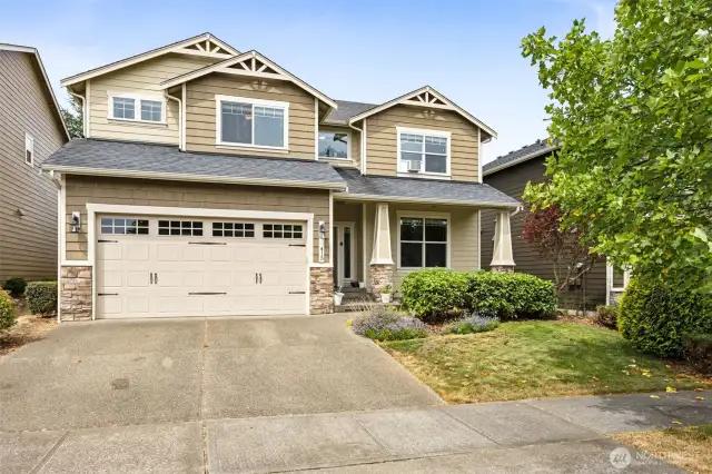 Let’s talk curb appeal, shall we? This two-story Craftsman-style home is a total knockout. With a gorgeous mix of two-tone paint colors, stone accents on the garage, and those timeless Craftsman roof details, this place is as stylish as it is welcoming. The covered porch is just begging for a pair of rocking chairs, and the carriage-style garage doors? They add a touch of classic elegance you just can't beat.
