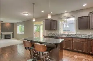 This shot from the kitchen is basically a blueprint for entertaining success. From the island, you have the perfect vantage point, overlooking the sink window and into the casual dining area in front of the slider, which opens up to the family room beyond. Whether you're prepping a meal, pouring drinks, or catching up with guests, this open layout ensures you never miss a moment.