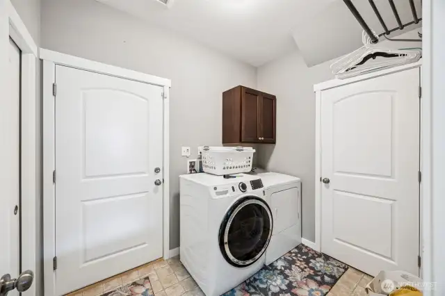 This laundry room is more than just a space for washing clothes, it’s a little slice of organization heaven. The neutral stone-style vinyl floors are waterproof, which means spills are no big deal. Tall ceilings give it a spacious feel, and the hanging rack is perfect for those items that need a little extra love. Shaker cabinets and the closet offer all the storage you’ll ever need, and the modern two-panel doors with an arched detail? Just a little touch of class for your laundry duties.