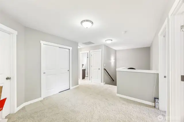 This loft-style open area at the top of the staircase is as functional as it is stylish. With a long storage closet and a separate linen closet next to the main bathroom entry, there’s no shortage of space for all your essentials. It’s the perfect spot for organizing linens, seasonal items, or anything you want tucked away but still easily accessible. The open design keeps the space feeling airy while offering practical storage solutions.