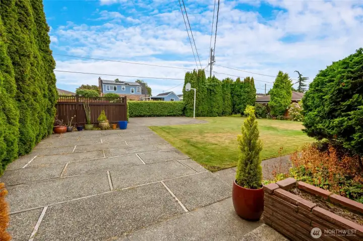 Huge backyard and patio in back with parking pad and basketball hoop.