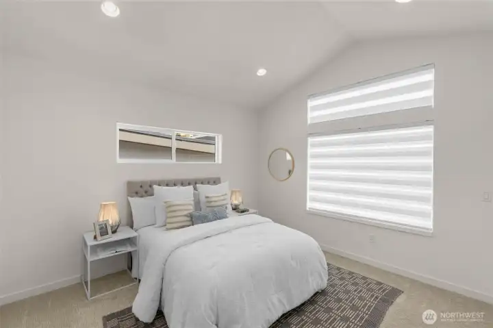 Primary bedroom retreat with expansive windows offers space for a king bed and a restful atmosphere.