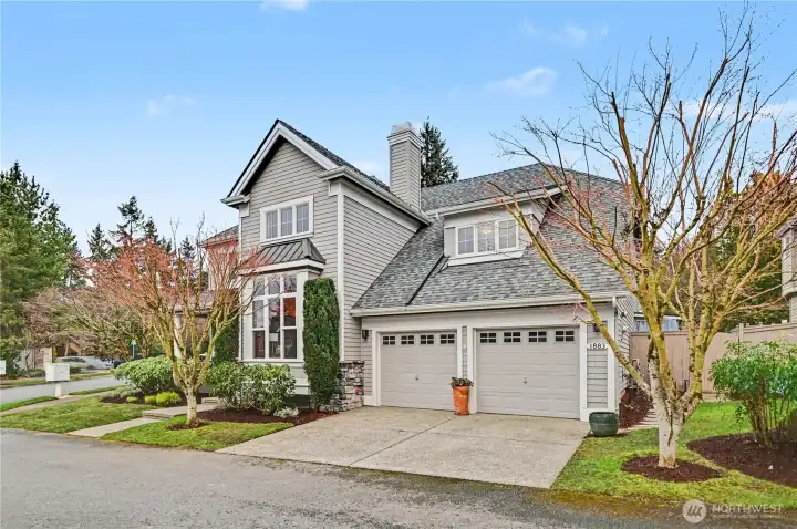 Striking curb appeal with sophisticated gray and white exterior accented by a vibrant red front door and two car garage.