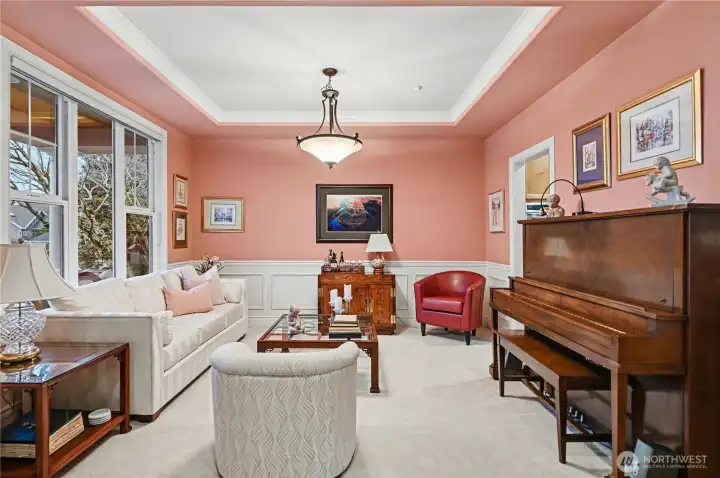 Beautiful architectural details, including tray ceilings and wainscoting, enhance the home’s charm, while expansive windows flood the space with natural light.