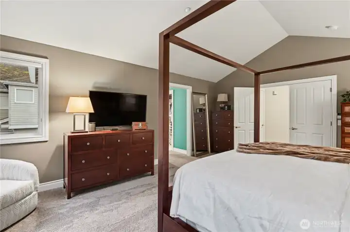Primary bedroom features double door entry, vaulted ceilings and large windows.