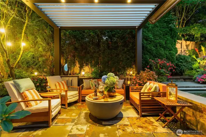 Inviting seating area beneath a custom-built luxury pergola with integrated lighting and heaters.