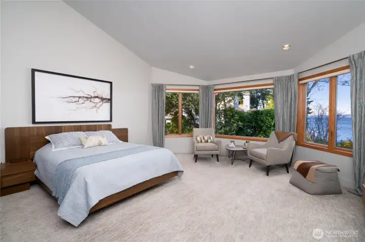 Primary bedroom with large windows and water views