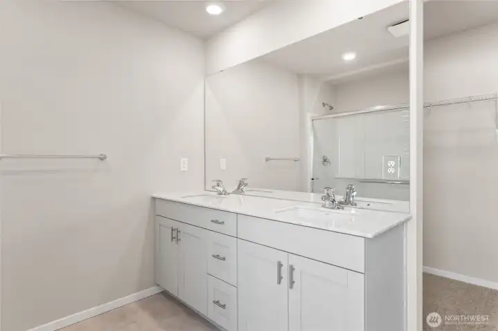 Primary en-suite bathroom featuring a dual-sink, and quartz countertop. Photos are representative only and may display different color packages and/or upgrades. Primary en-suite bathroom featuring a dual-sink, and quartz countertop. Photos are representative only and may display different color packages and/or upgrades.