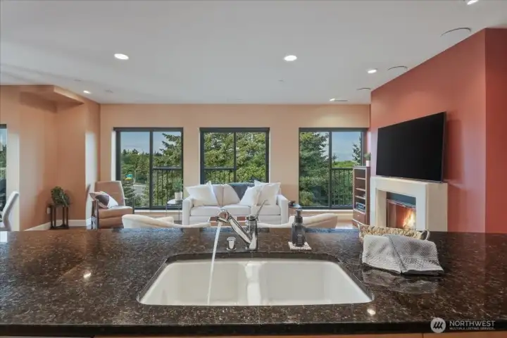 Kitchen island w/ sink, granite counters, open concept, gas fireplace