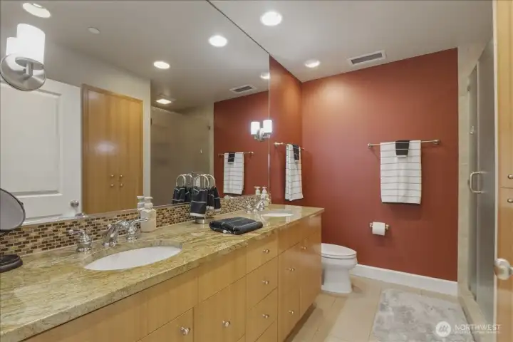 Ensuite primary bath w/ double vanity, tile floor, walk-in tile shower, storage