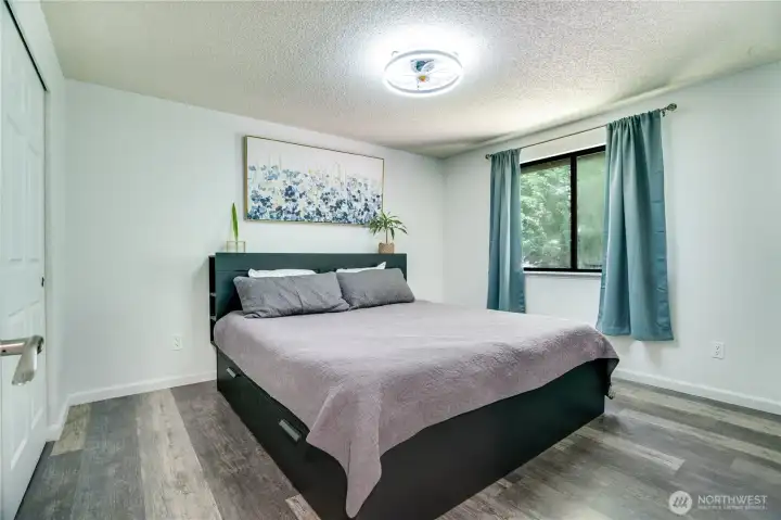 A fresh new light fixture and warm natural light make this primary bedroom the perfect place to start and end your day.
