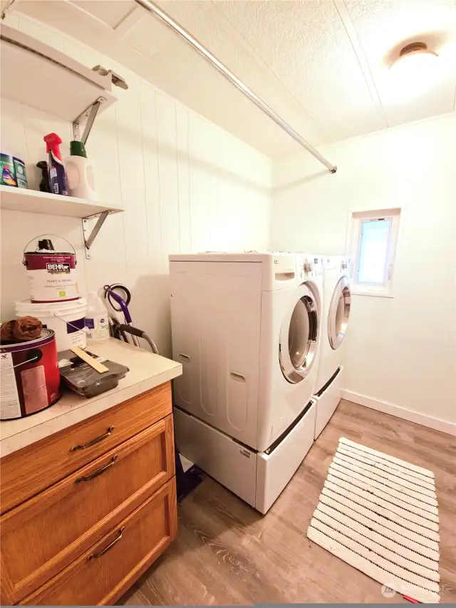LG washer and dryer or mounted on new pedestals. Convenient hanging rod, and new cabinet with counter space for folding.