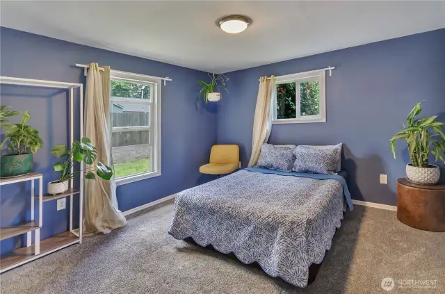 Spacious and serene, this primary bedroom offers plush carpeting, bold accent walls, and abundant natural light from dual windows. A restful retreat to start and end your day