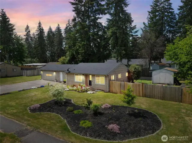 Twilight charm and warm curb appeal! This cozy home glows with inviting evening light, beautifully framed by fresh landscaping and a peaceful, spacious yard. A perfect place to come home to.