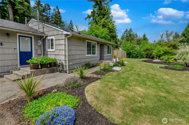 Bursting with curb appeal! This beautifully landscaped yard welcomes you home with fresh flowers, lush greenery, and a cheerful blue door—setting the tone for charm both inside and out.