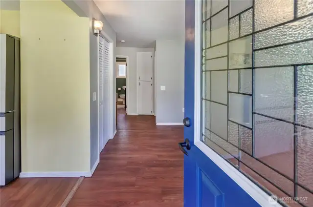 Step inside! This inviting entryway greets you with warm wood floors, fresh paint, and a glimpse into the heart of the home. A perfect blend of charm and functionality awaits just beyond the blue door.