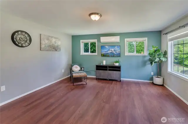 Bright, stylish, and move-in ready! This living space features rich wood flooring, a mini-split for year-round comfort, and fresh paint with a modern accent wall. Natural light fills the room—perfect for relaxing or entertaining.