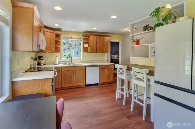 A cheerful and functional kitchen filled with natural light! Featuring warm wood cabinetry, updated appliances, and a cozy breakfast nook with a view—this space is ready for morning coffee or evening meals with loved ones.