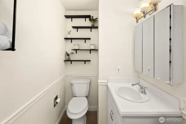 Bathroom makes great use of space with mirrored storage and lots of shelving.