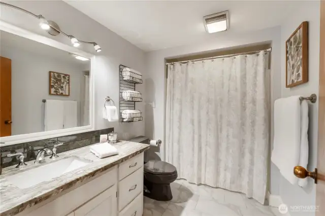 Lower level full bath w/ Quartz counters and tiled floor.