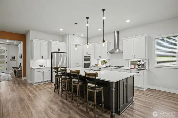 An entertainer’s kitchen showcasing a generous quartz island, modern lighting, and an open layout that blends style with everyday function.