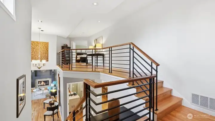 Sleek custom staircase and open railing bring in lots of natural light to the upper level.