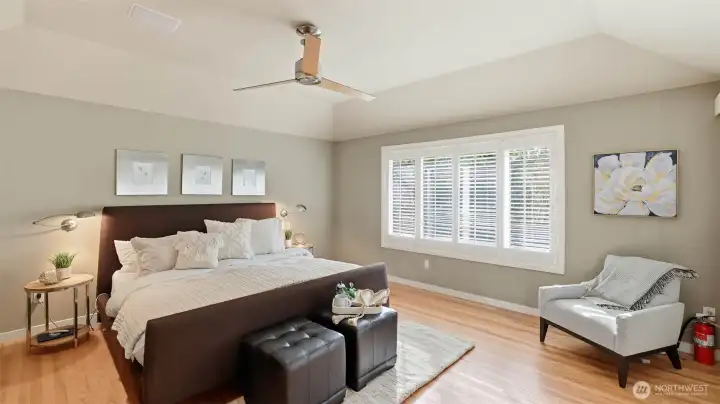 The private primary suite offers a serene retreat with peaceful views of the expansive backyard and towering fir trees.