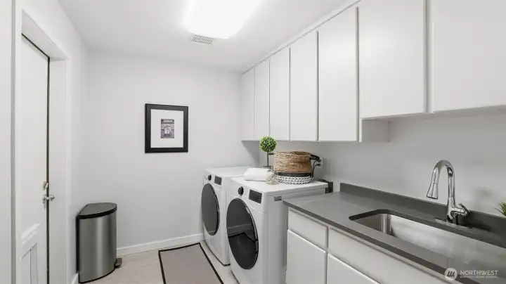 Main floor utility room with access to the backyard. Note, the door is designed to offer in and out opportunities for your 4-legged friends.