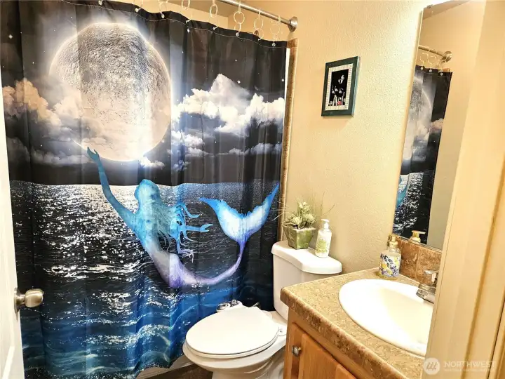 The bathroom off the hallway features a raised toilet, a bidet, and a bathtub with a shower.