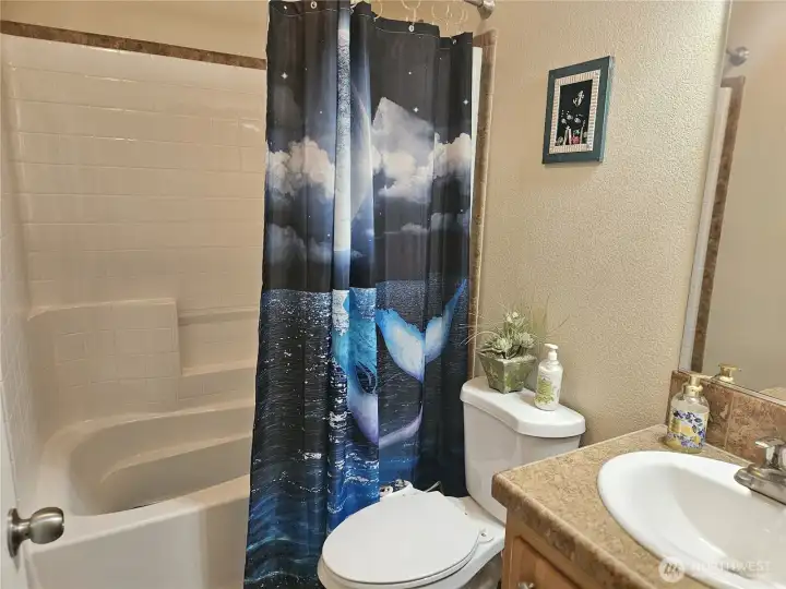 The bathroom off the hallway features a raised toilet, a bidet, and a bathtub with a shower.