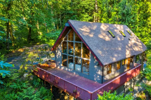 Windows throughout enhance the lighting and colors that enter the home. And imagine the hours you'll spend on the wrap around deck experiencing the sights and sounds of the forest.