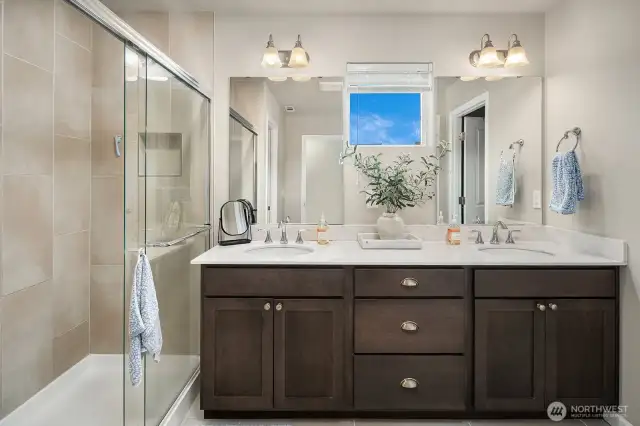 Luxurious Primary Bathroom, features maple cabinets, quartz countertops, dual sinks, tile shower and double sided walk-in closet.