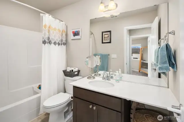 2nd Bathroom on top floor features maple cabinet, quartz countertop, stylish light fixtures, soaking tub & shower.