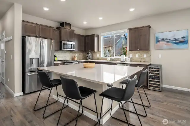 Kitchen features maple cabinetry, stylish quartz countertops, engineered hardwood floors and stainless steel appliances.  Kitchen windows overlooks naturally landscaped side yard.