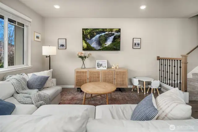 Cozy living area has a built in flat screen TV.  Stairs lead to upper level of home.