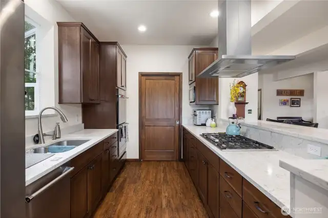 Termador Gas Stovetop. Kitchen made for entertaining. Natural gas stove. Door ahead leads to walk in pantry. Cherry cabinets have pullout drawers.